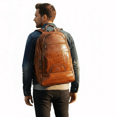 A man wearing a tan leather backpack for men with a crocodile texture on a white background.